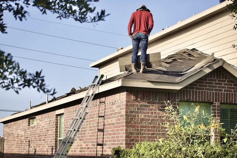 Professional roofer working on a residential roof in West Covington